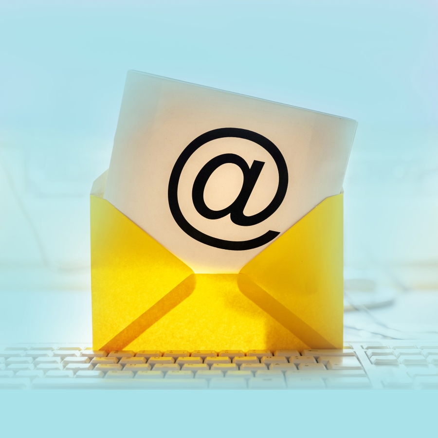 Tastatur auf dieser ein gelber Brief steht und der Inhalt ist in @-Zeichen